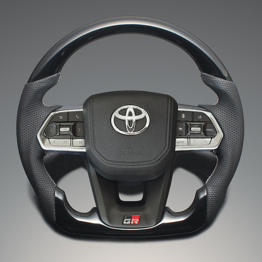 高品質の証ユーロステッチ採用 (ピアノブラックxシルバーステッチ) 純正交換ガングリップステアリング ランクル  300系 R3/8- LS224 ヒーター対応